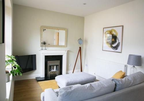 a living room with a couch and a tv at Skipton Centre, superb 2 bedroom cottage in Skipton