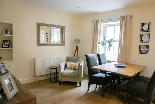 ein Wohnzimmer mit einem Esstisch und einem Stuhl in der Unterkunft Skipton Centre, superb 2 bedroom cottage in Skipton