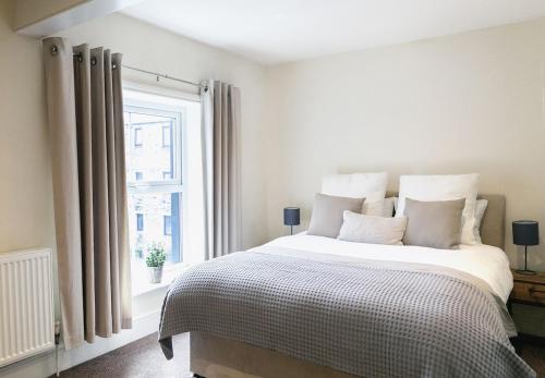ein Schlafzimmer mit großem Bett und Fenster in der Unterkunft Skipton Centre, superb 2 bedroom cottage in Skipton