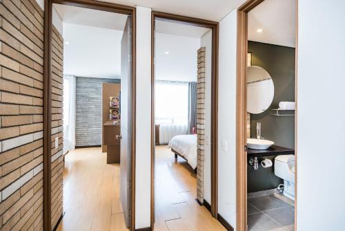 a room with sliding doors leading to a bedroom at Hotel Viaggio Nueve Tres in Bogotá