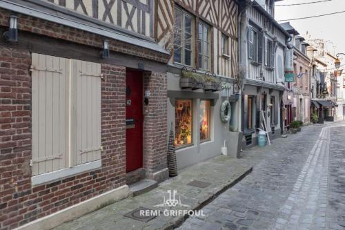 une rue vide avec un bâtiment en briques et un magasin dans l'établissement Confidentielle House Historic City Center 4 Guests, à Honfleur