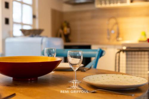 - une table en bois avec un bol et un verre de vin dans l'établissement Confidentielle House Historic City Center 4 Guests, à Honfleur