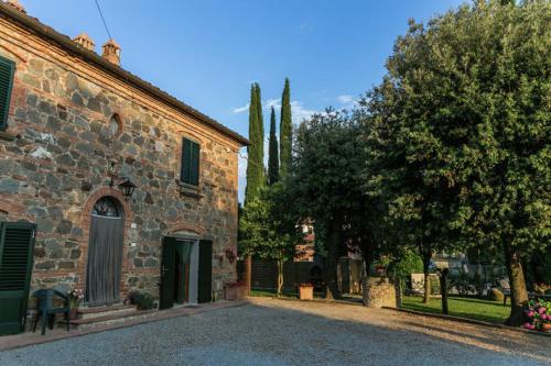 an old stone building with trees in the background at Agriturismo Casal Gheriglio in Lucignano
