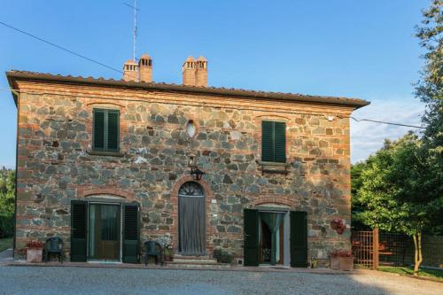 an old stone building with green shutters at Agriturismo Casal Gheriglio in Lucignano
