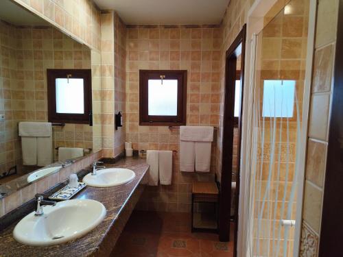 a bathroom with two sinks and two mirrors at Estudio El Tosca in Beceite