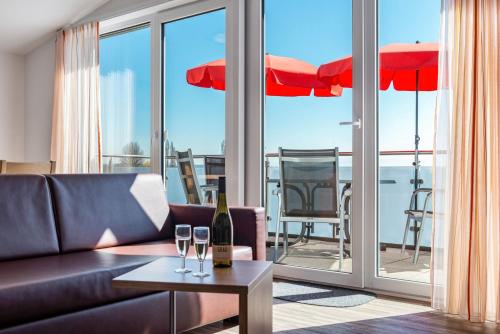 a living room with a couch and a table with wine glasses at Gästehaus D i c k r e i t e r in Immenstaad am Bodensee