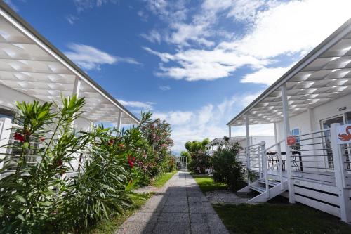 a walkway between two buildings with flowering plants at San Benedetto Camping Relais in Peschiera del Garda