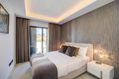 Un dormitorio con una cama grande y una ventana grande. en The Next Gen Villa, en Estepona