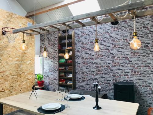 une salle à manger avec une table et un mur de briques dans l'établissement L'Atelier du Bien Etre with private spa, à Verlincthun