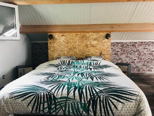 une chambre avec un grand lit avec un mur de briques dans l'établissement L'Atelier du Bien Etre with private spa, à Verlincthun