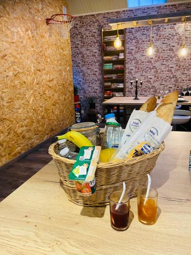 deux paniers de pain et de boissons sur une table dans l'établissement L'Atelier du Bien Etre with private spa, à Verlincthun
