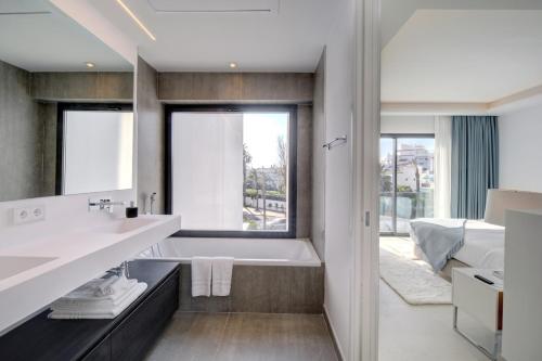 Un baño con bañera y una gran ventana. en The Next Gen Villa, en Estepona