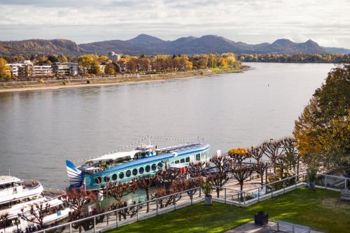 a blue and white boat on the river at AMERON Bonn Hotel Königshof in Bonn