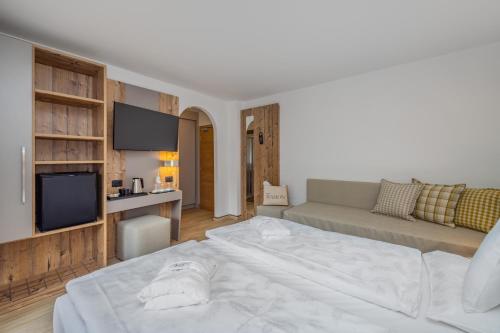 a living room with a large bed and a couch at Hotel Ramon in Campitello di Fassa
