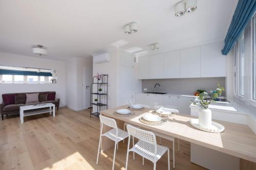 a kitchen and living room with a table and chairs at Bright CityView Apartment with AC near PGE Narodowy by Noclegi Renters in Warsaw