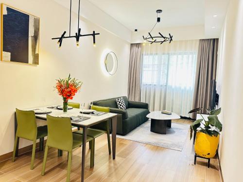 a living room with a table and a green couch at Greenland Apartment by Link in Kigali