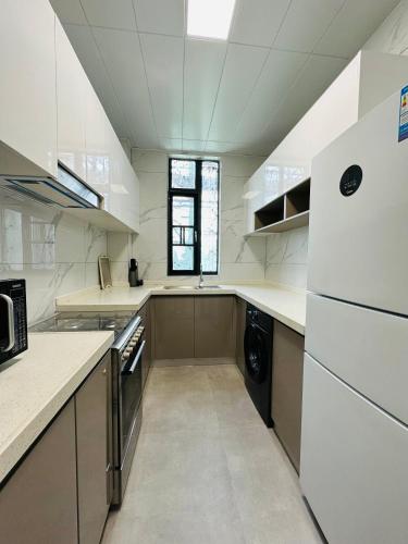 a large white kitchen with a sink and a dishwasher at Greenland Apartment by Link in Kigali