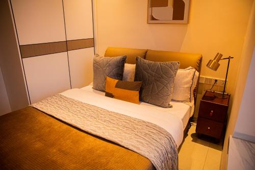 a bedroom with a bed with pillows on it at Greenland Apartment by Link in Kigali