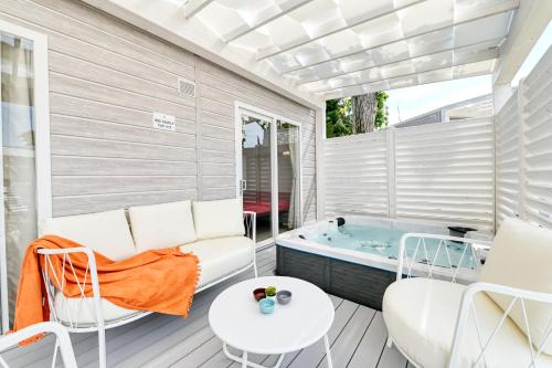 a patio with a tub and a table and chairs at San Benedetto Camping Relais in Peschiera del Garda
