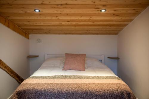 a bed in a room with wooden ceilings at Pépite Alpine - Centre ville - WIFI in Barcelonnette