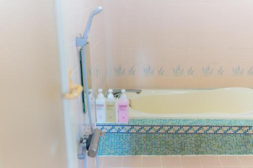 a bathroom with a bath tub with bottles of soap at Hotel Lucia at Maebashi Akagi in Maebashi