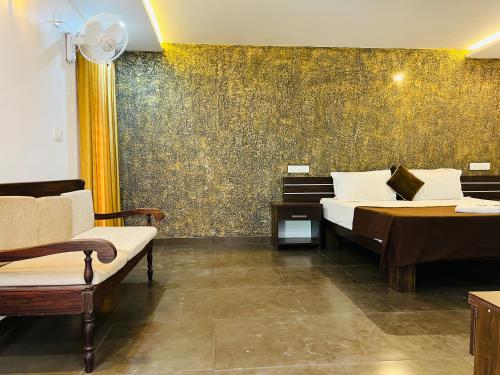 a bedroom with two beds and a wall with gold wallpaper at Empire One Bedroom with Common Pool in Wayanad