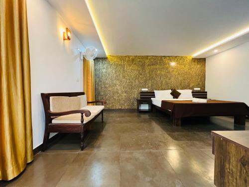 a bedroom with a bed and a couch and a desk at Empire One Bedroom with Common Pool in Wayanad