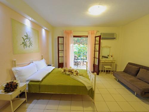 - une chambre avec un lit, un canapé et une fenêtre dans l'établissement Iliotropio Studios, à Loutra Edipsou