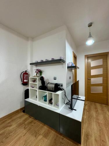a living room with a shelf and a table at Apartamento Berria in Pamplona