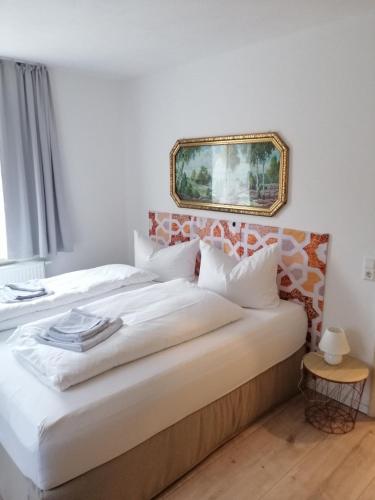 a bedroom with a bed with a picture on the wall at Gasthaus Pension Bretthäusl in Glashütte