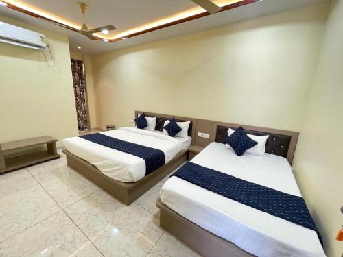 Un dormitorio con dos camas con sábanas azules y blancas. en Hotel Mb Nirala Shyam, en Khātu
