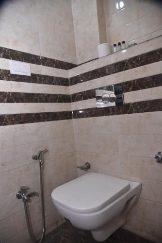 a bathroom with a white toilet and a shower at Hotel R S RESIDENCY in Varanasi