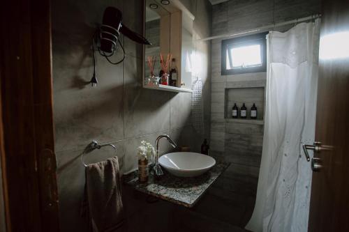 a bathroom with a white sink and a window at Malaica in Tafí del Valle