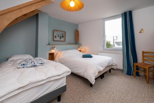 two twin beds in a room with a window at Maison Ty Sioul - proche plage in Quiberon