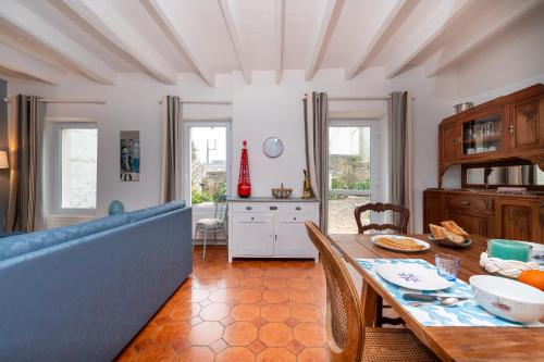 un salon avec une table et un canapé bleu dans l'établissement Maison Ty Sioul - proche plage, à Quiberon