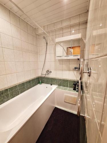 a bathroom with a bath tub and a sink at Emvika Tauragė apartment in Tauragė