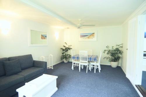a living room with a couch and a table and chairs at Debbie's Place in Rainbow Beach