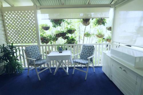 a balcony with a table and two chairs and plants at Debbie's Place in Rainbow Beach