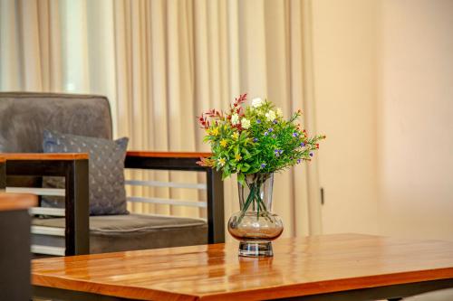 a vase of flowers sitting on a table at Rebero A3s apartment in Kigali