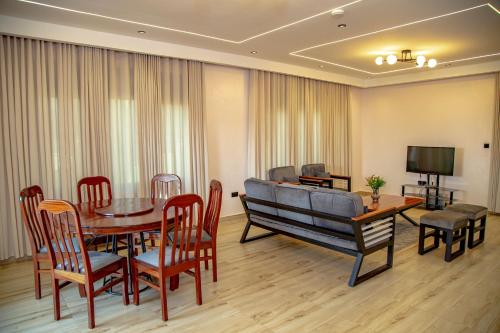 a dining room with a table and chairs and a couch at Rebero A3s apartment in Kigali
