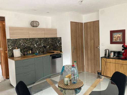 une cuisine avec une table en verre dans l'établissement Maison de Lorraine, à Chavelot