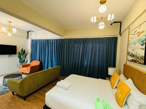 a bedroom with a bed and a couch and a chair at Urban Living Residence in Kuala Lumpur