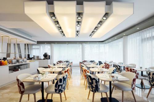 a restaurant with tables and chairs in a room at Eurostars Embassy in Vienna