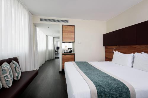 a hotel room with a large bed and a bathroom at Eurostars Embassy in Vienna