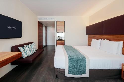 a hotel room with a large bed and a chair at Eurostars Embassy in Vienna