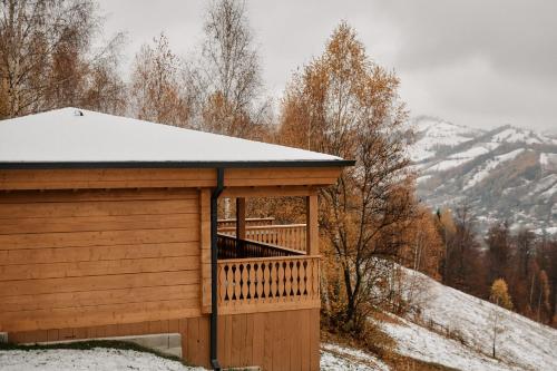a wooden cabin with a snow covered roof at Matca Hotel Relais & Châteaux in Şimon