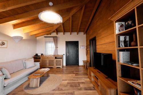a living room with a couch and a tv at Matca Hotel Relais & Châteaux in Şimon