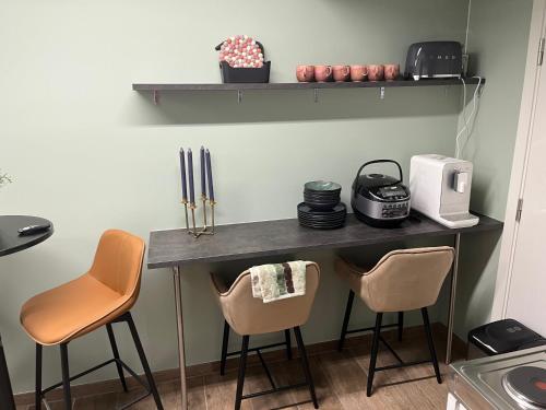 a kitchen with a counter with two chairs and a table at Apartment enjoy and swim in Oslo