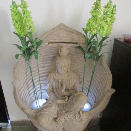 a vase with a statue on a table with flowers at Hotel & Spa La Mansion del B Azul in Querétaro