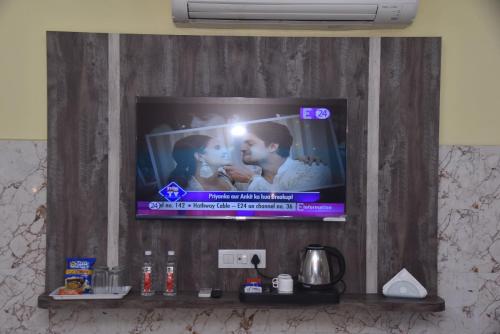 a television on a wall in a room at Hotel R S RESIDENCY in Varanasi